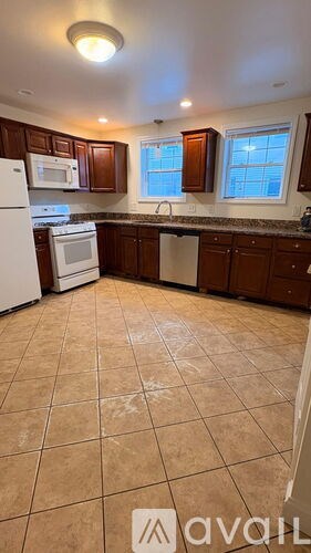 A kitchen with brown cabinets and a white refrigerator.
