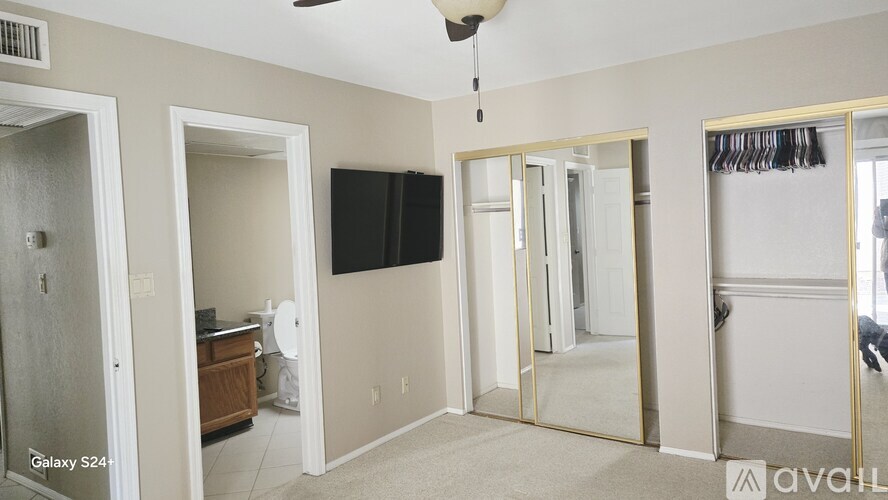 A room with a ceiling fan and a wall-mounted TV.