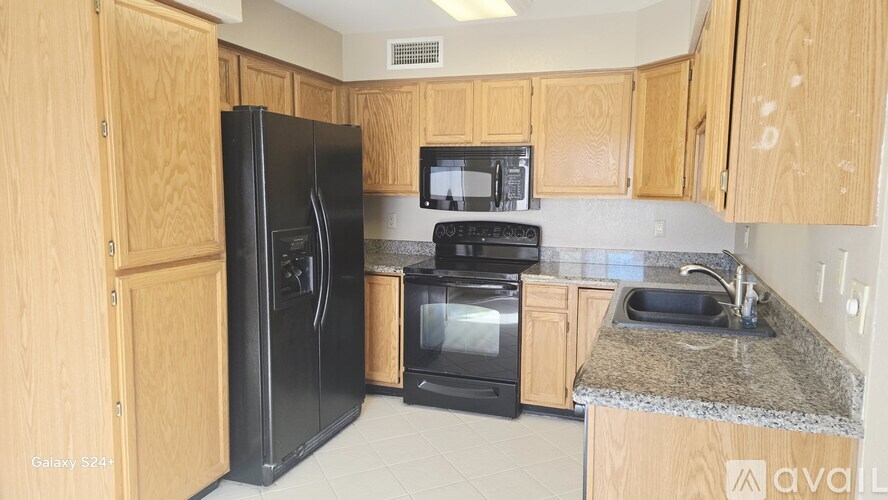 A kitchen with wooden cabinets and black appliances.