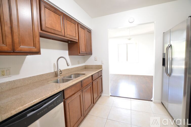 A kitchen with wooden cabinets and a stainless steel refrigerator.
