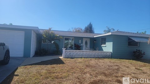 A house with a blue exterior and a white car parked in front.