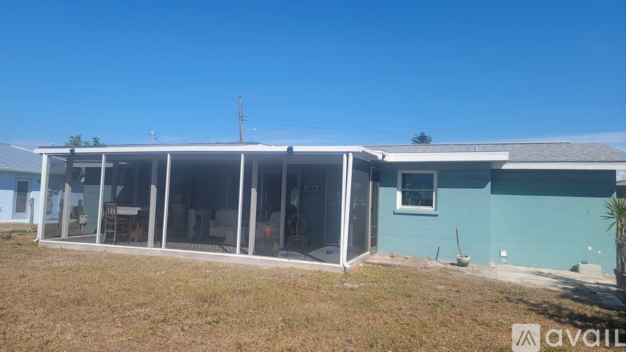 A blue house with a white roof and a glass door is available for rent.