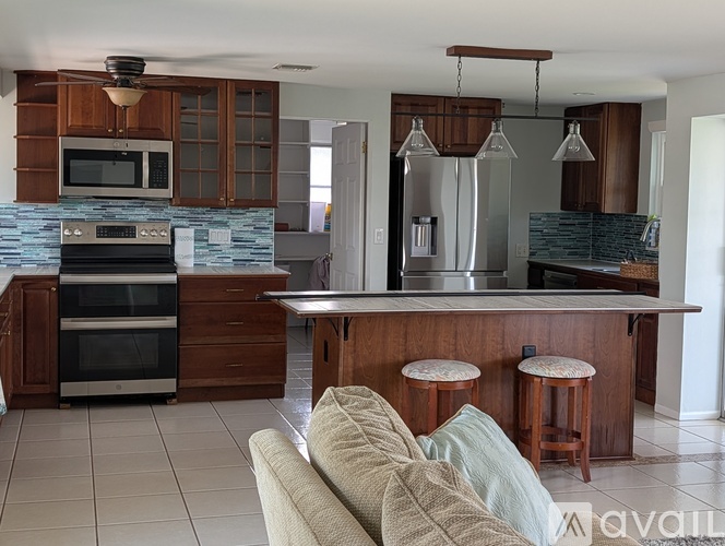 A kitchen with a bar stool and a couch.