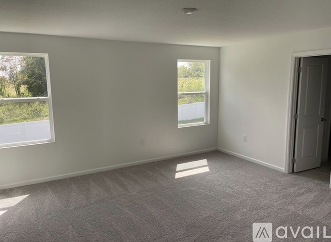A room with a window and a door is available for rent.