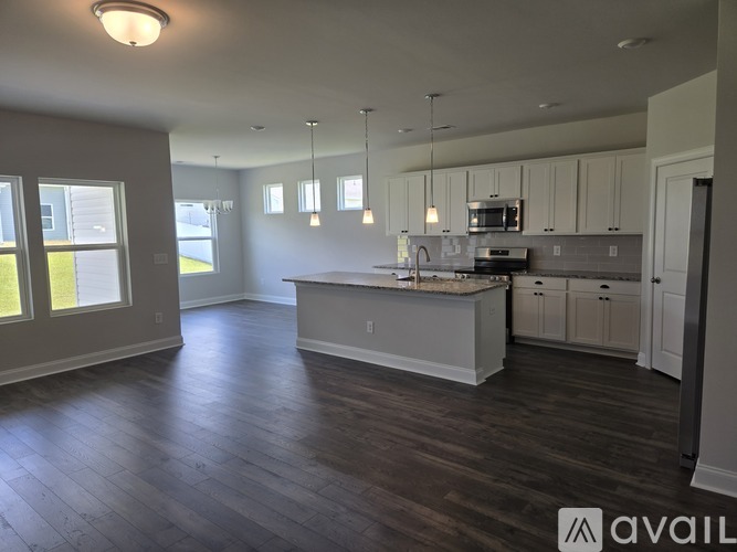 A spacious kitchen with white cabinets and a central island.