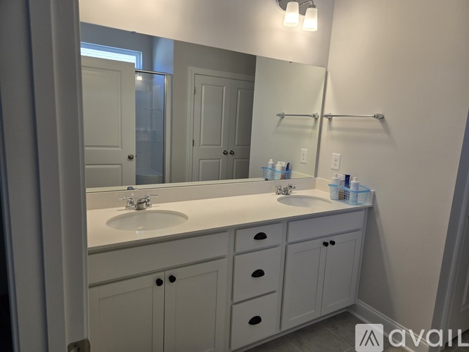 A bathroom with a white sink and cabinets.