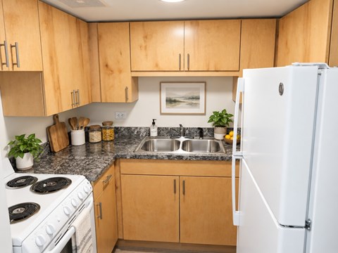 A kitchen with wooden cabinets and a white refrigerator.