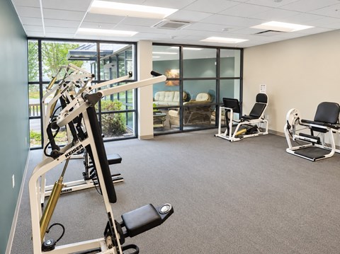 A gym with a weight machine and a bench.