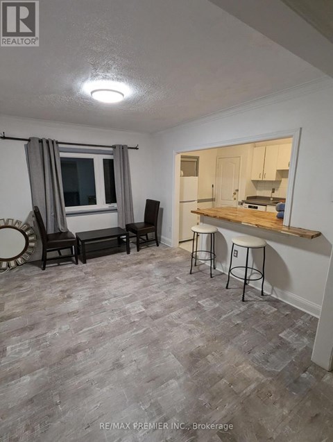 A living room with a grey carpet and a bar area.