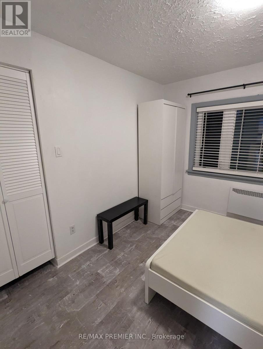 A bedroom with a bed, bench, and window.