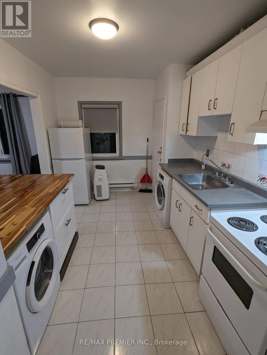 A kitchen with white appliances and a wooden counter top.