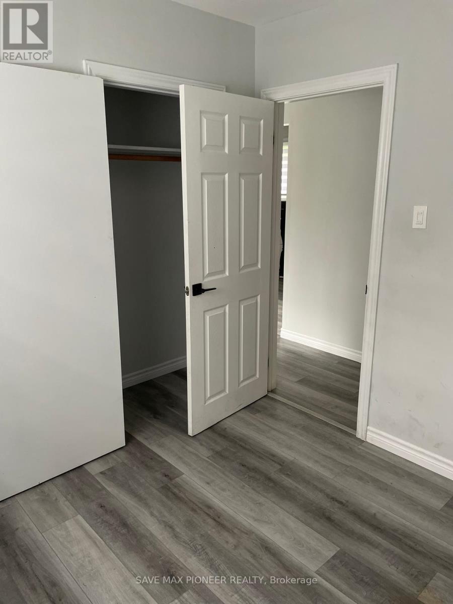 A white door is open in a room with grey flooring.