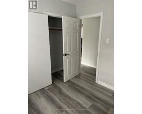 A white door is open in a room with grey flooring.
