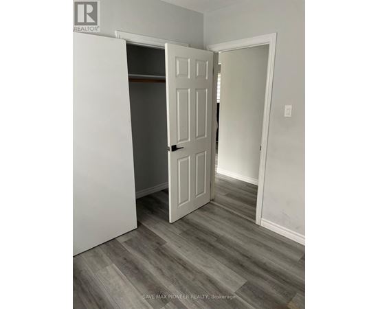 A white door is open in a room with grey flooring.