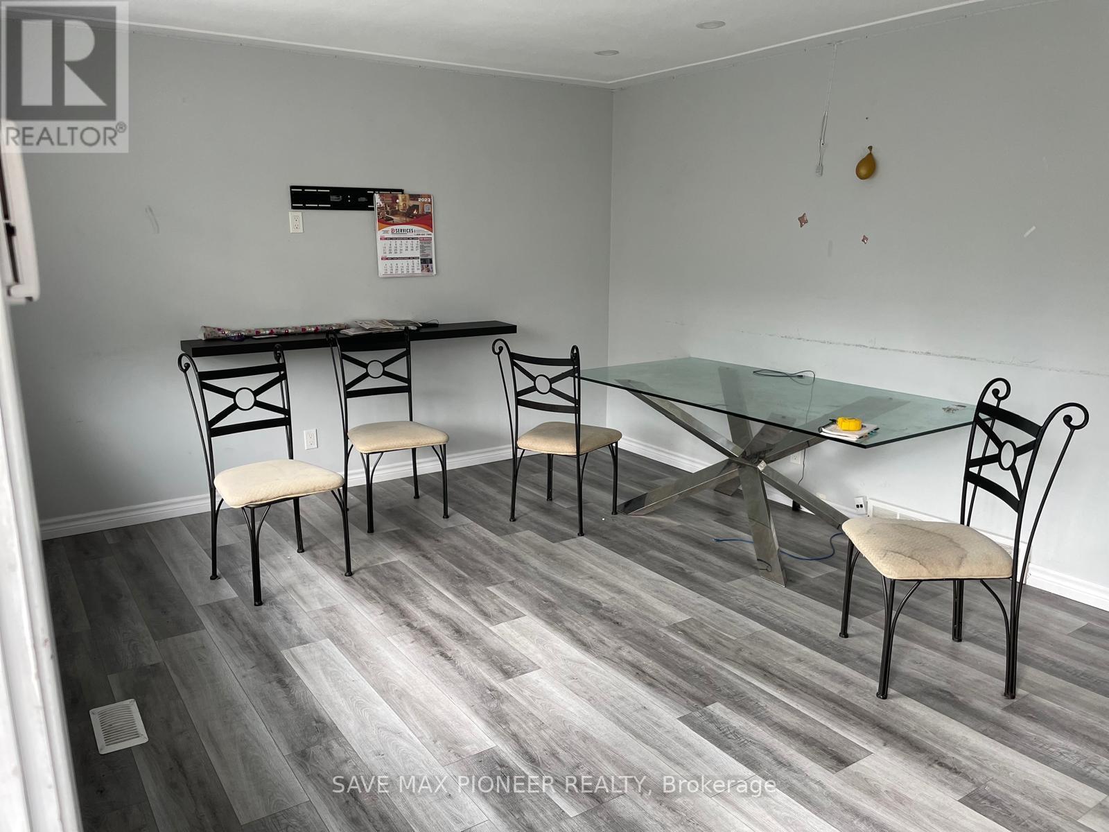 A dining room with a glass table and chairs.