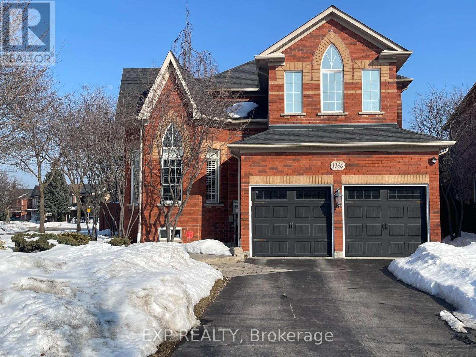 A red brick house with a black garage door.