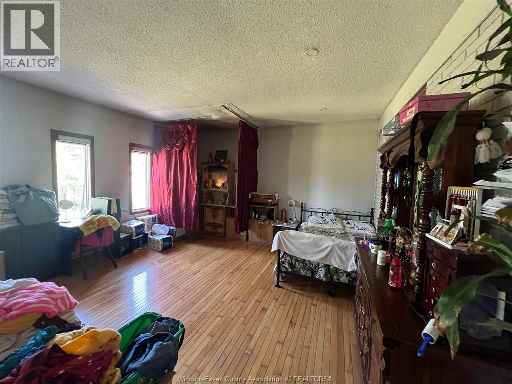 A room with a bed, a chair, and a table with various items on it.
