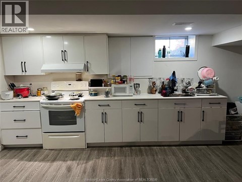 A kitchen with white cabinets and appliances.