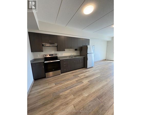 A kitchen with wood flooring and modern appliances.