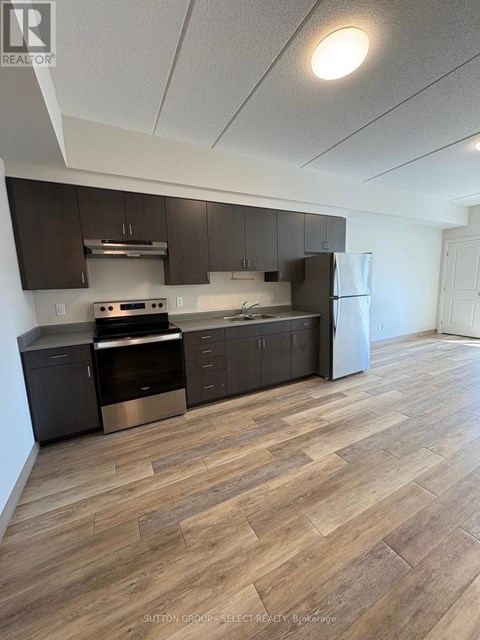 A kitchen with wood flooring and modern appliances.