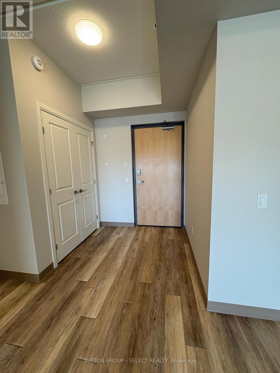 A hallway with wood flooring and a white door.