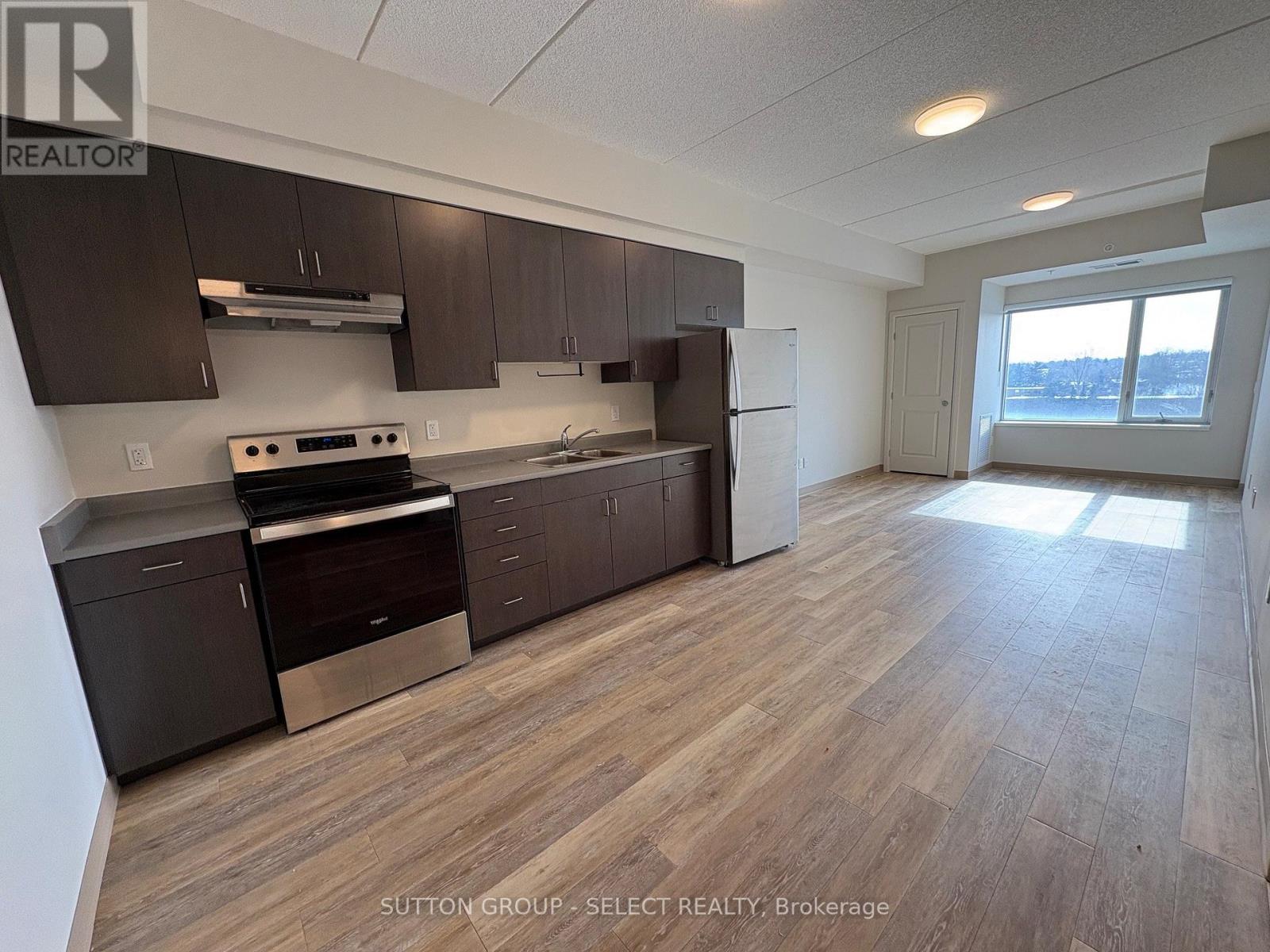 A kitchen with dark brown cabinets and a stainless steel oven.