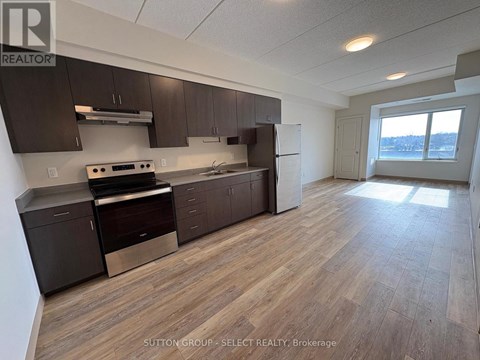 A kitchen with dark brown cabinets and a stainless steel oven.
