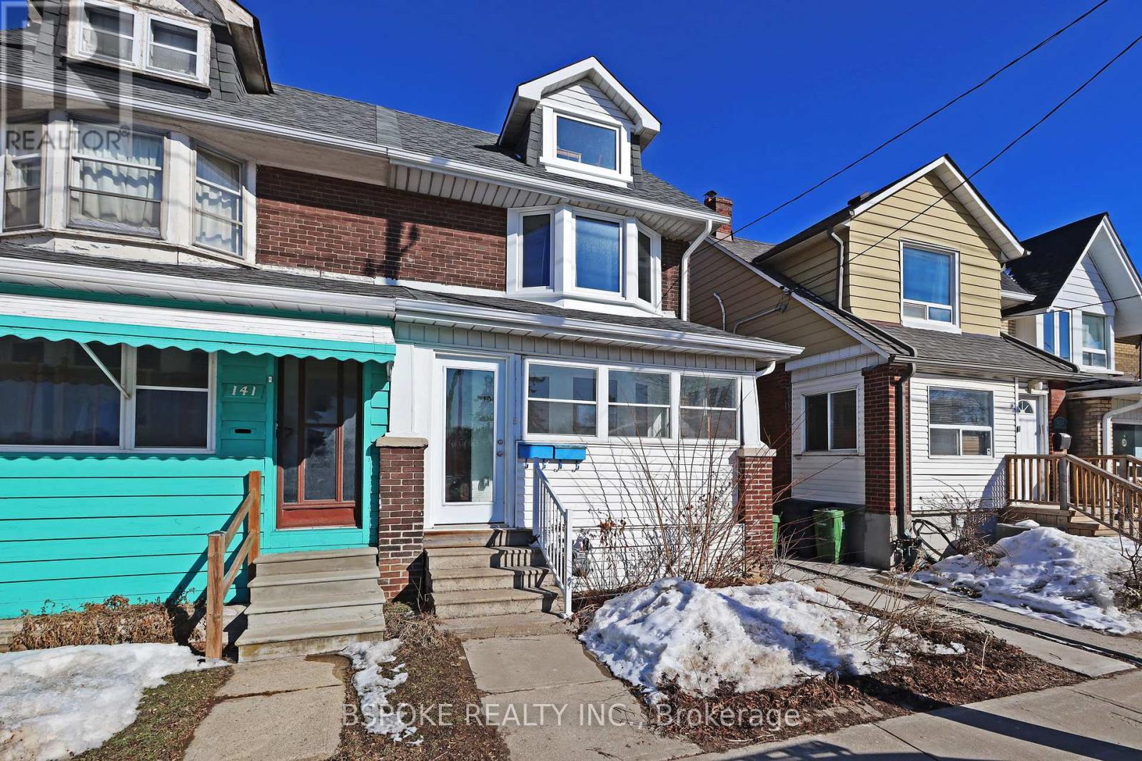 A row of houses with a blue sky in the background.