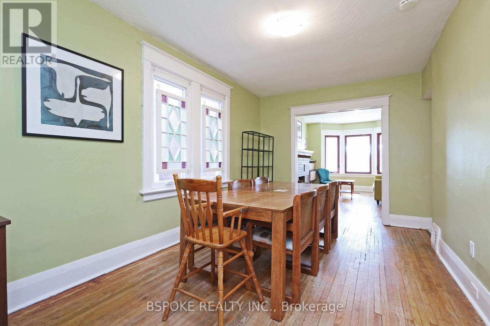A dining room with a wooden table and chairs.
