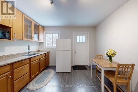A kitchen with wooden cabinets and a white refrigerator.