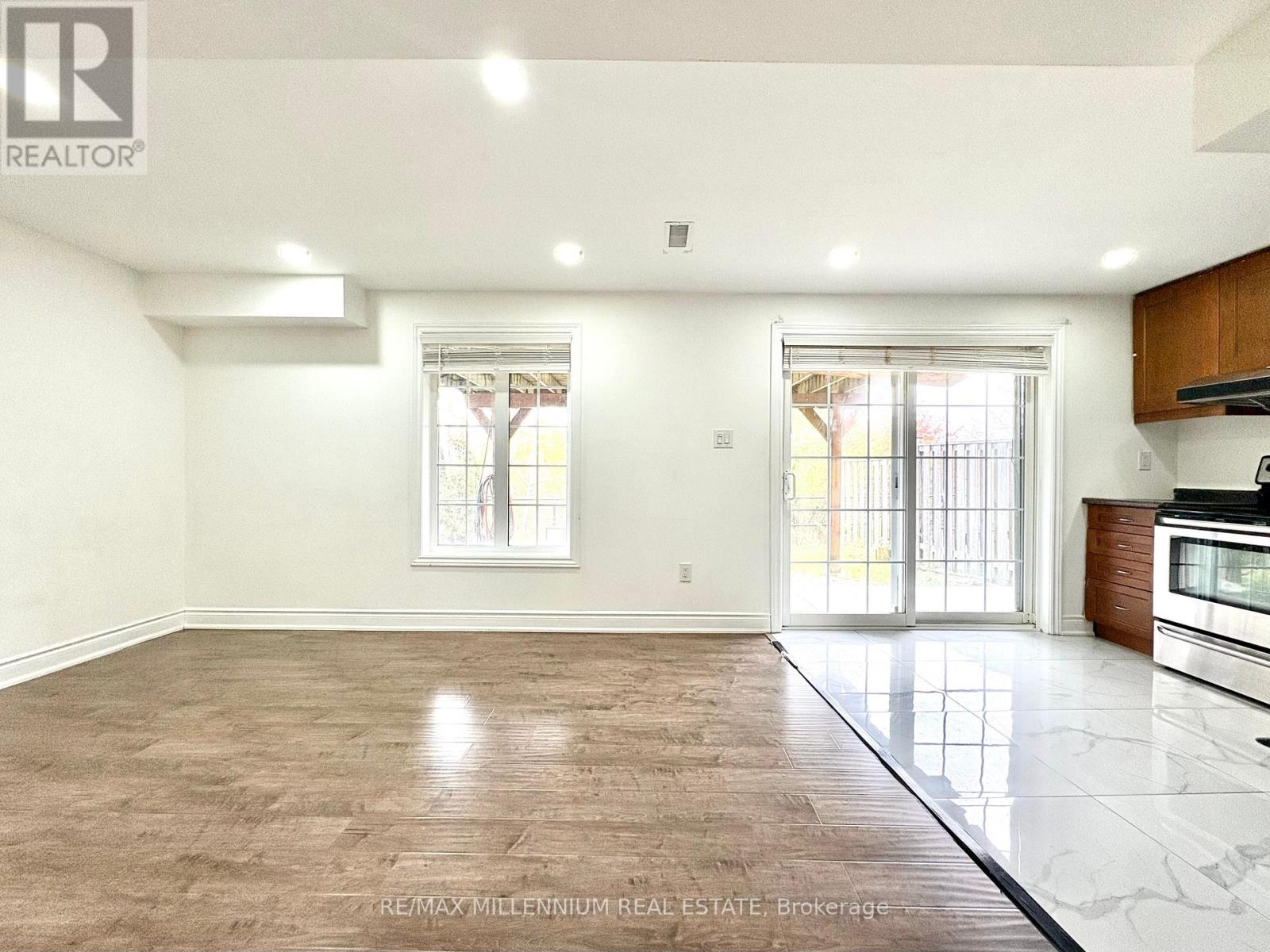 A spacious room with a large window and a sliding glass door.