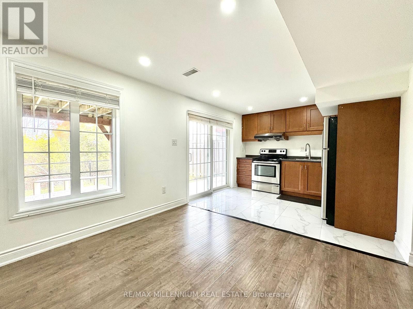 A spacious kitchen with wooden cabinets and a marble countertop.