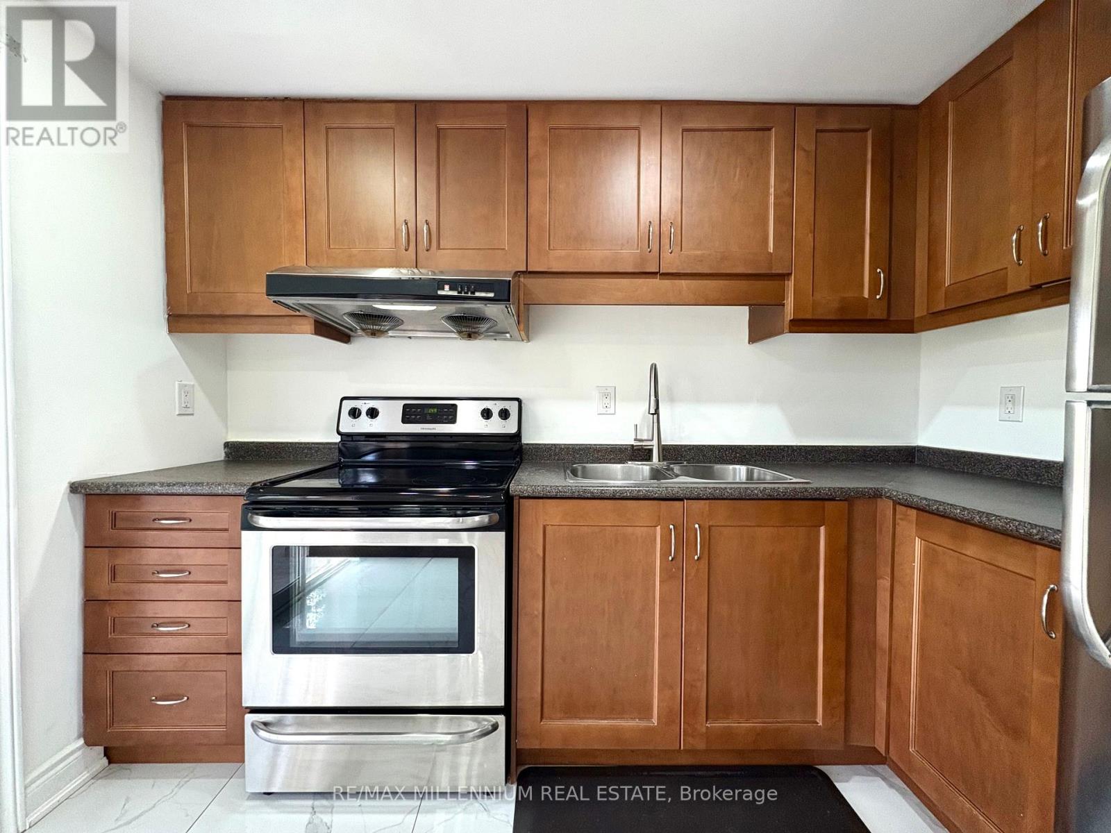 A kitchen with wooden cabinets and a stove top oven.