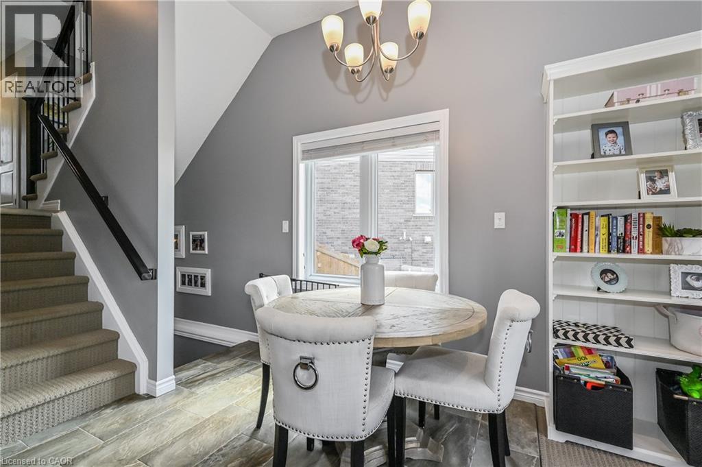 A dining room with a table and chairs and a staircase.