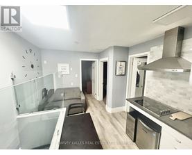 A modern kitchen with a glass countertop and stainless steel appliances.