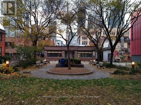 A park with a fountain surrounded by benches and trees.