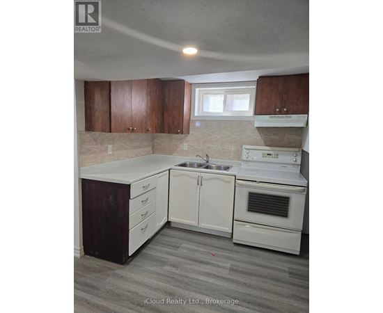 A kitchen with white appliances and wooden cabinets.