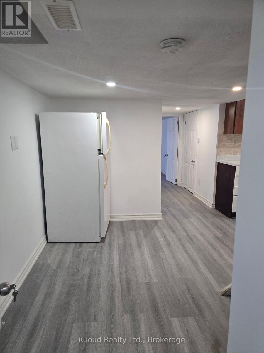A room with a white door and grey carpeting.