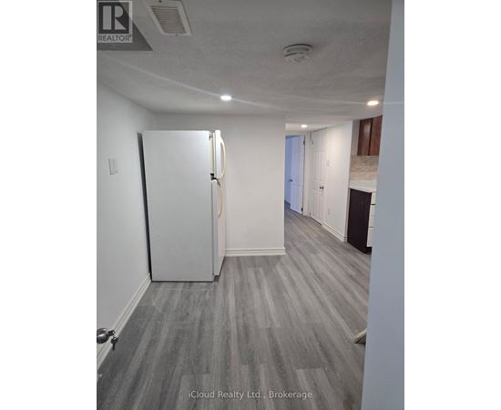 A room with a white door and grey carpeting.
