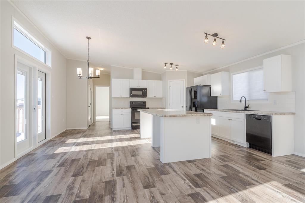 A modern kitchen with a large island and stainless steel appliances.