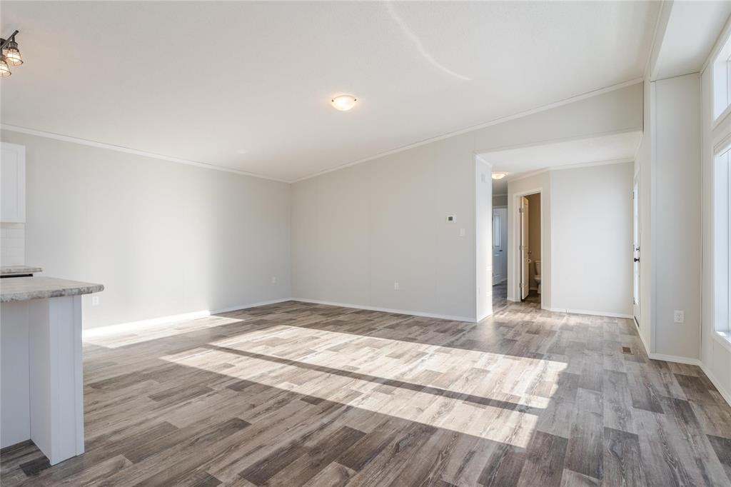 A spacious room with a wooden floor and white walls.