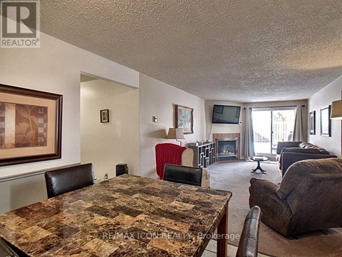 A living room with a brown granite table and brown leather chairs.