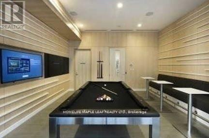 A pool table in a room with wooden walls and a TV mounted on the wall.