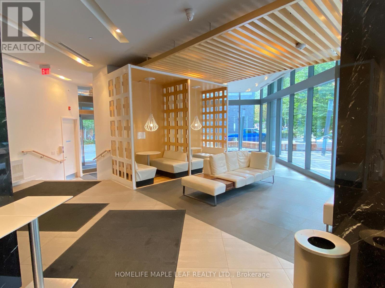 A spacious waiting area with white furniture and a wooden partition.
