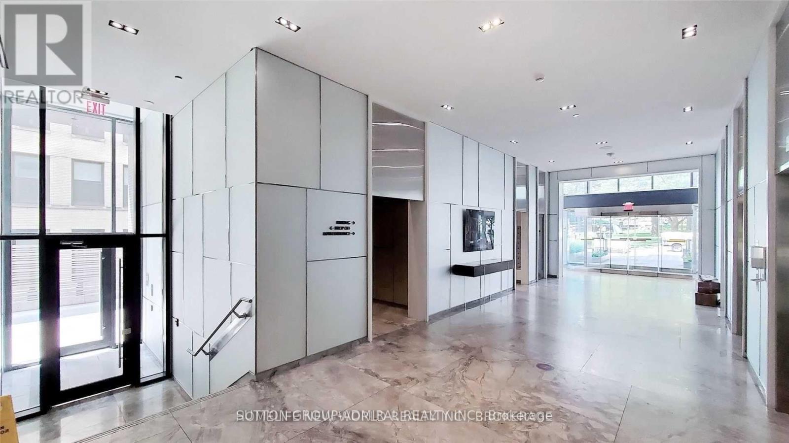 A spacious lobby with marble floors and a staircase leading to the second floor.