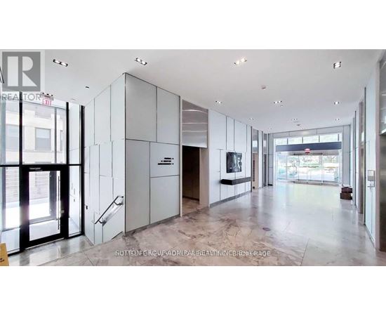 A spacious lobby with marble floors and a staircase leading to the second floor.