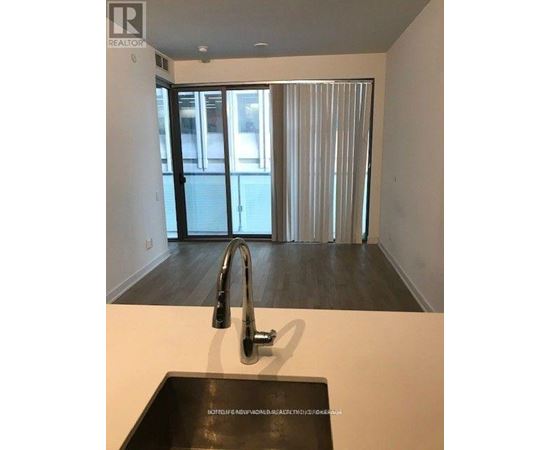 A modern kitchen with a sink and a window with blinds.