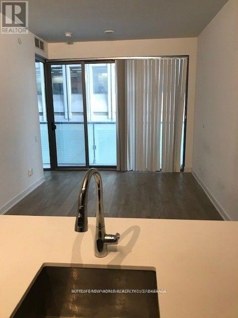 A modern kitchen with a sink and a window with blinds.