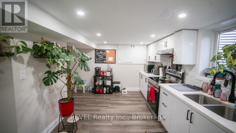 A kitchen with white cabinets and a wooden floor.
