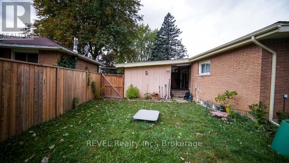 A backyard with a pink shed and a wooden fence.